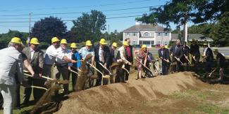 A group of people with hard hats and shovels